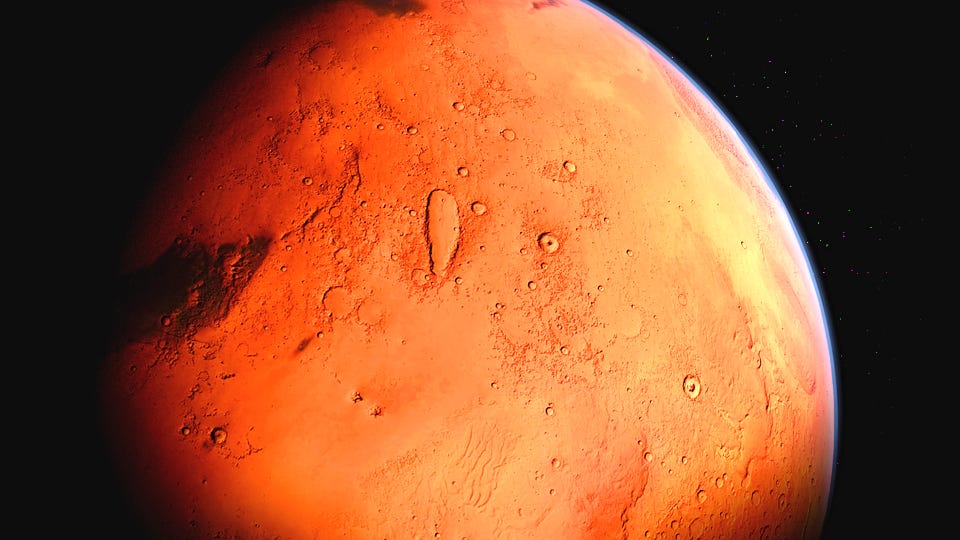 A close-up view of the red planet Mars, showing its rocky terrain and glowing orange atmosphere.