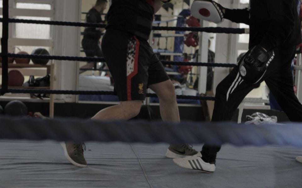 The feet and legs of two boxers as they train in the ring