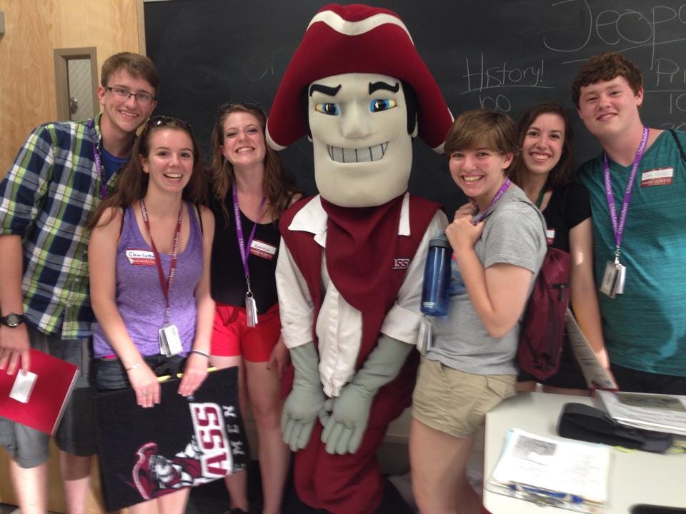 A photo of the author posing with friends and mascot Sam the Minuteman at UMass Amherst summer orientation.