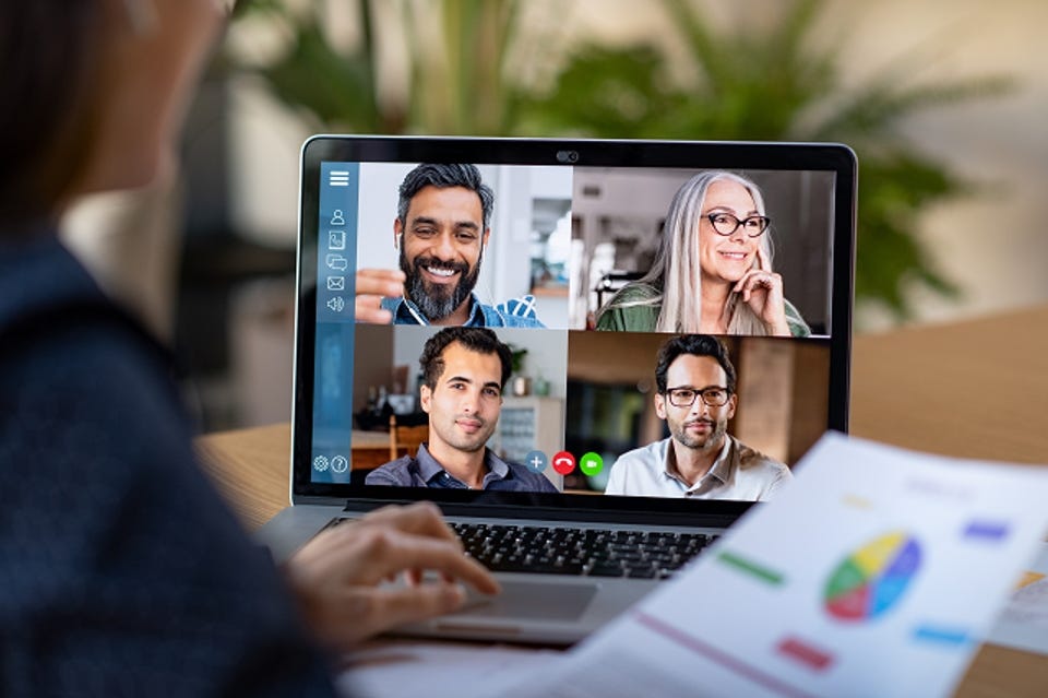 Freelancers/Consultants Online meeting with four smiling professionals on a laptop