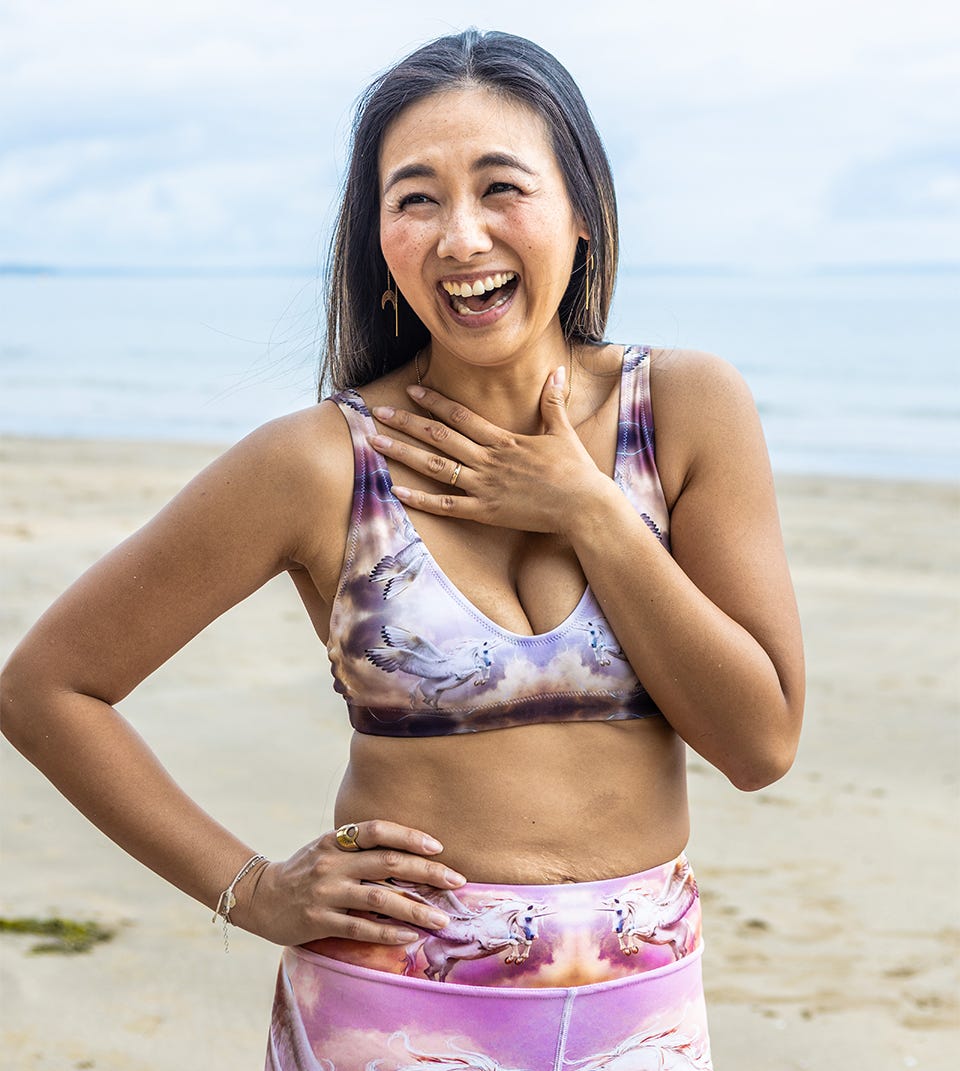 women laughing on beach wearing yoga outfit by dancingvishnu