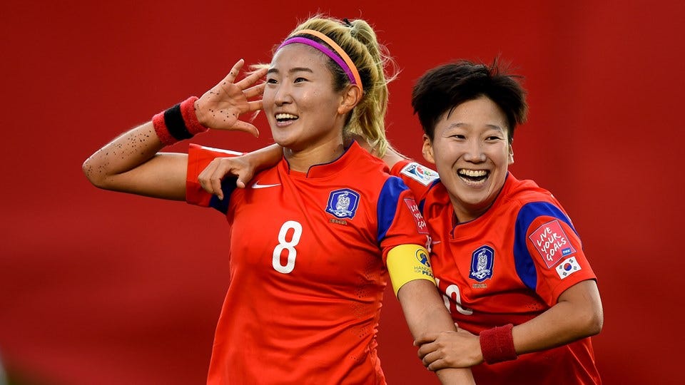 photo of Korea players celebrating scoring a goal