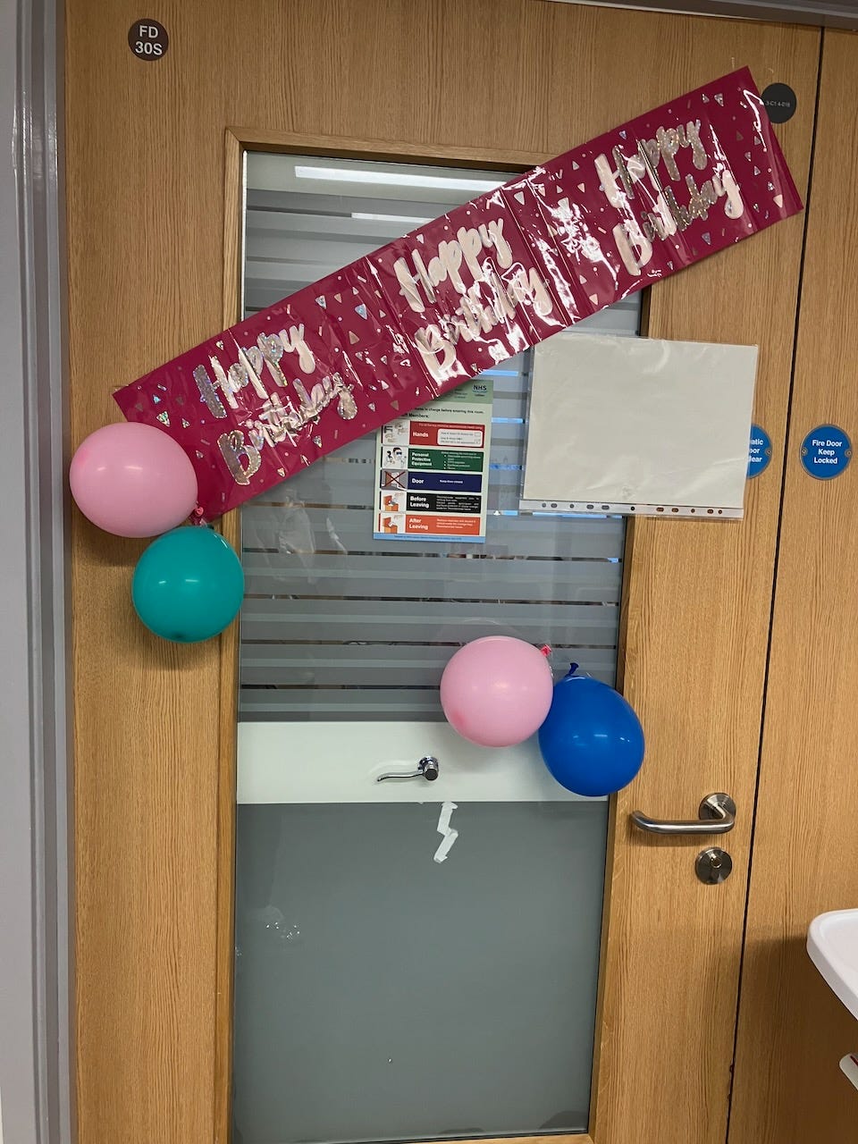 My child’s hospital door, decorated with balloons and a happy birthday banner for their birthday.