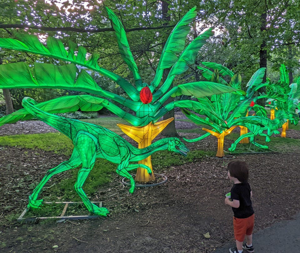 Child meets velociraptor dinosaur at the Dragon Lights Festival in Reno, NV (© April Orcutt)