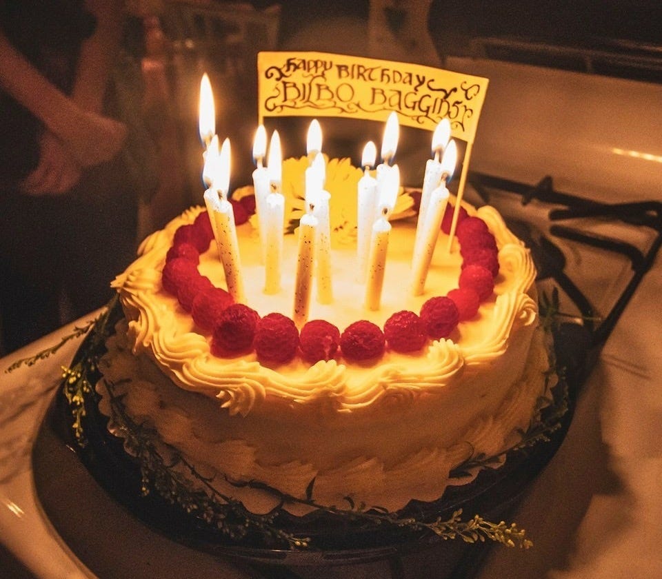 Vanilla birthday cake for Bilbo Baggins with fresh raspberries and lit candles