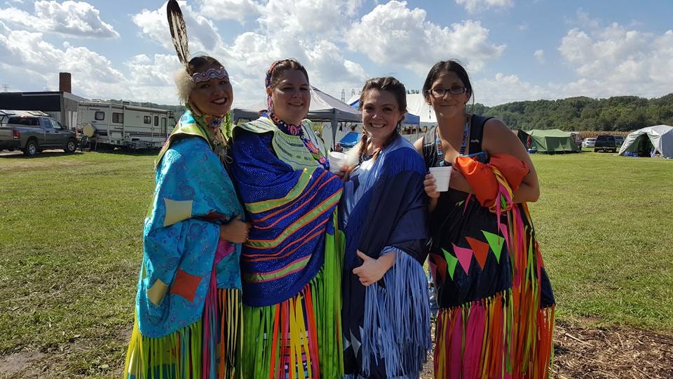 Four indigenious women in traditional regalia.