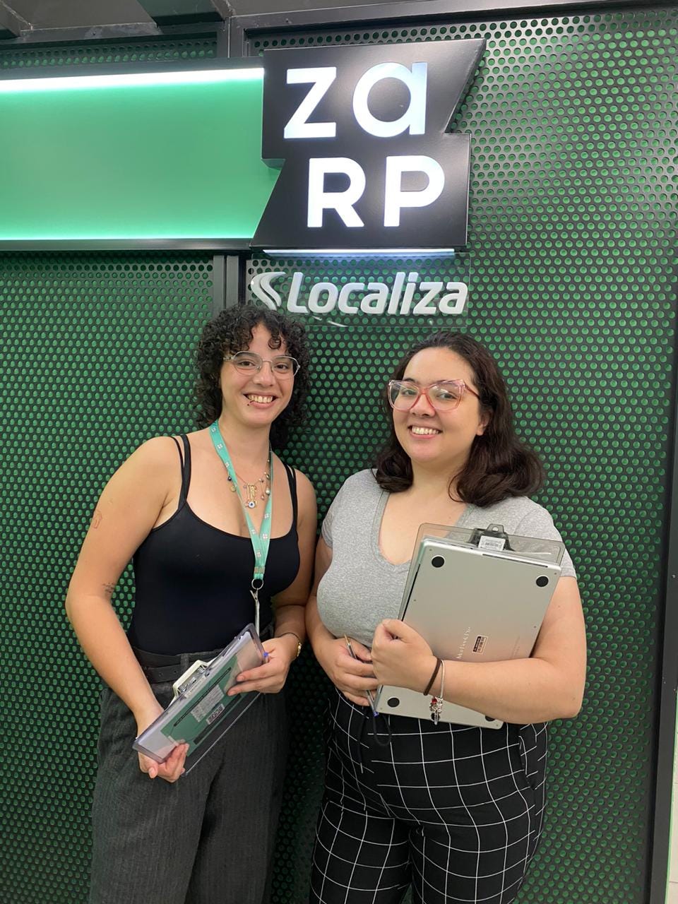 Duas mulheres brancas sorrindo em frente da placa "Zarp — Localiza"