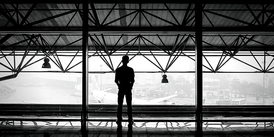 Man staring out window at airplane-”The Essence of Endeavor” by “Arthur G. Hernandez”