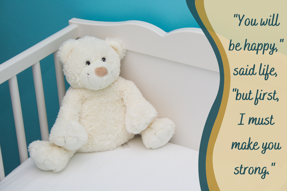 Cream-colored teddy bear in a white cradle. “You will be happy,” said life, “but first, I must make you strong.”