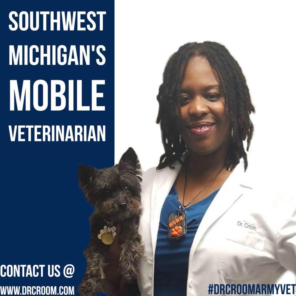 Dr. Croom Army veterinarian holding small black dog in an ad for her mobile veterinary services.