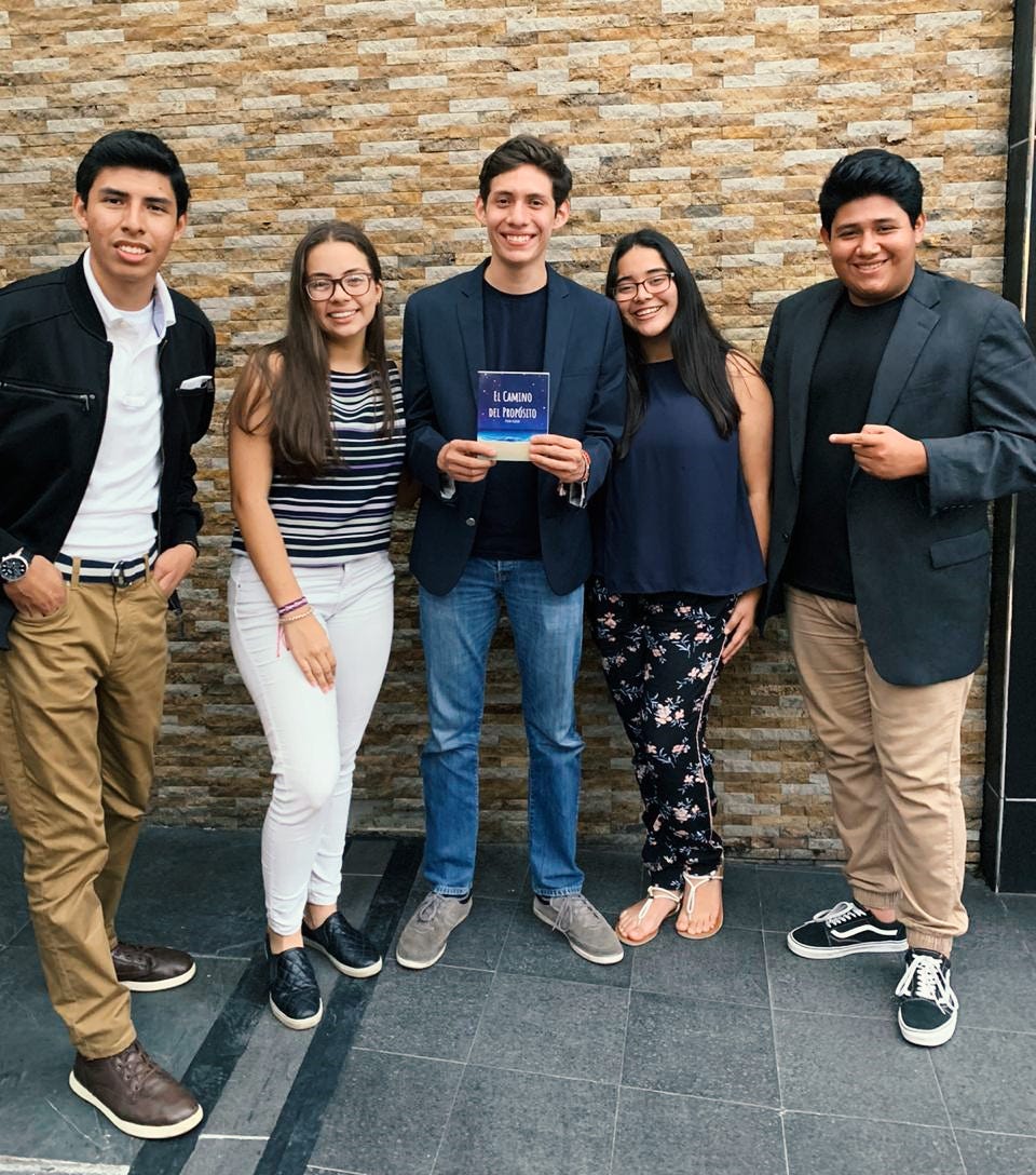 Dylan Siliezar y sus amigos posando con el libro el camino del propósito