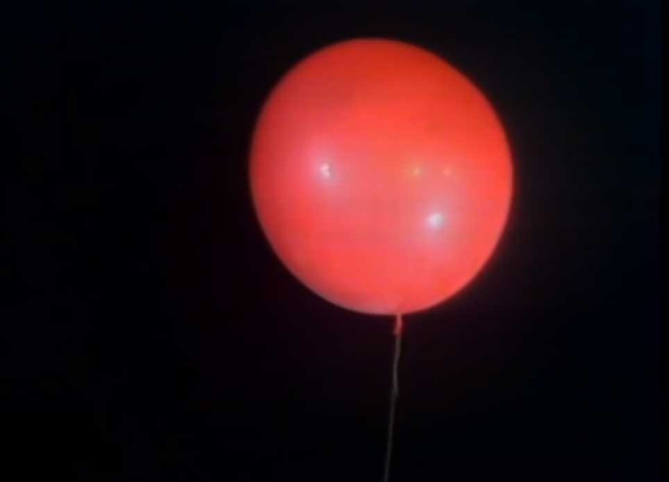 Image of the lone red balloon being set free and ascending toward the sky.