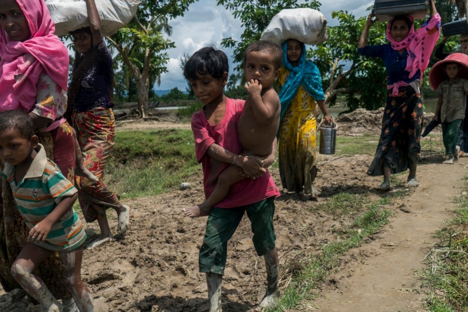 Petit garçon rohingya porte son petit frère pour traverser la frontière