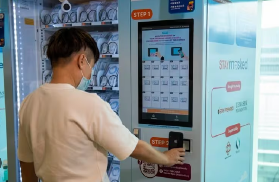 User claiming their free mask at a vending machine.