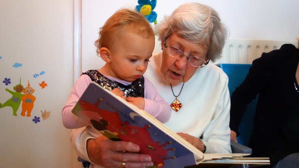 A grandmother reading to her child