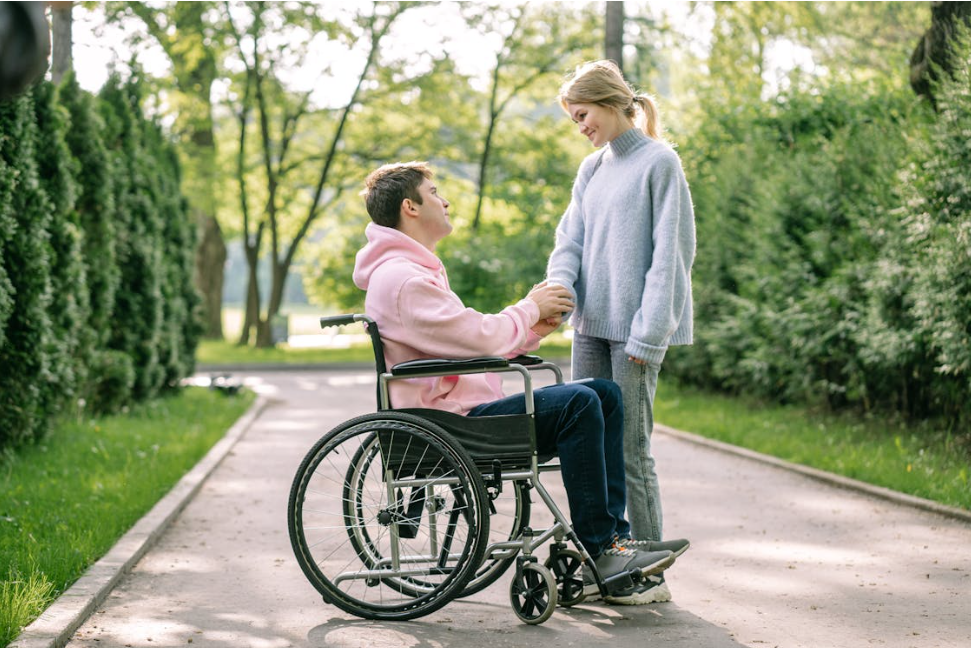 A Man Sitting on the Wheelchair Looking His Girlfriend