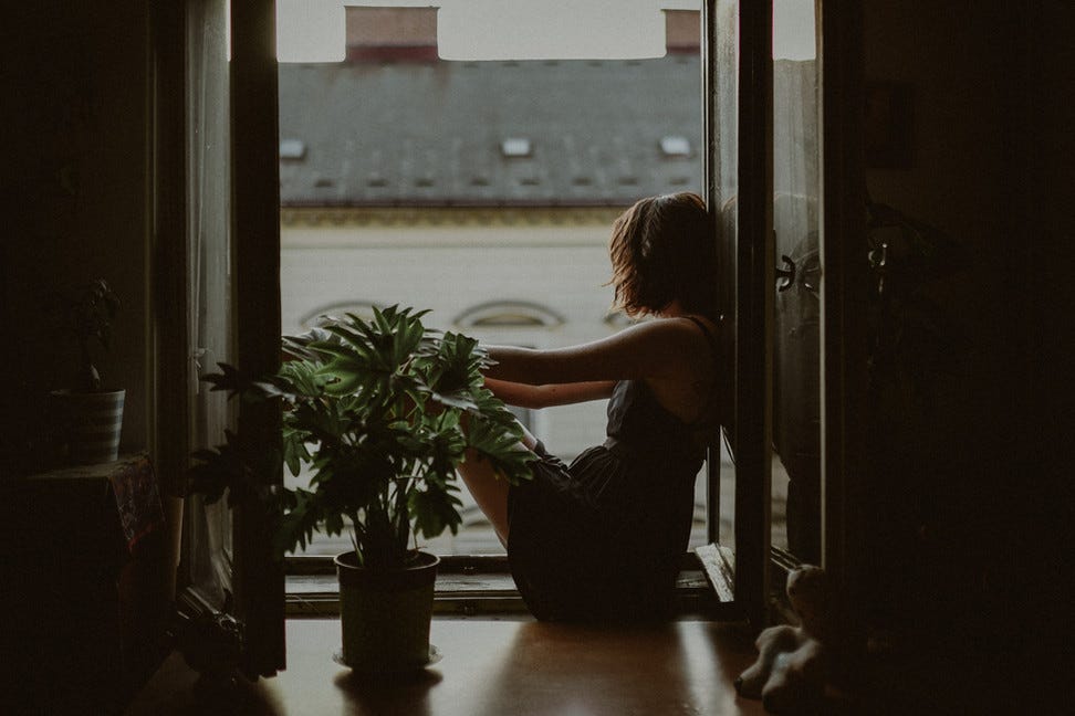Young woman looking out from her balcony