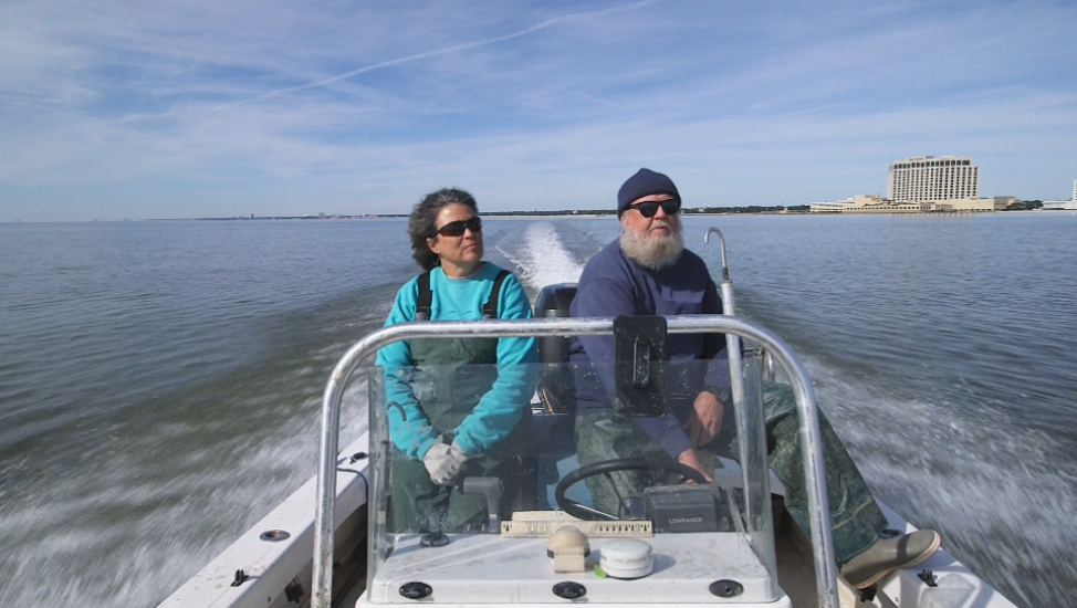 Oyster farmers piloting a boat in the Gulf of Mexico.