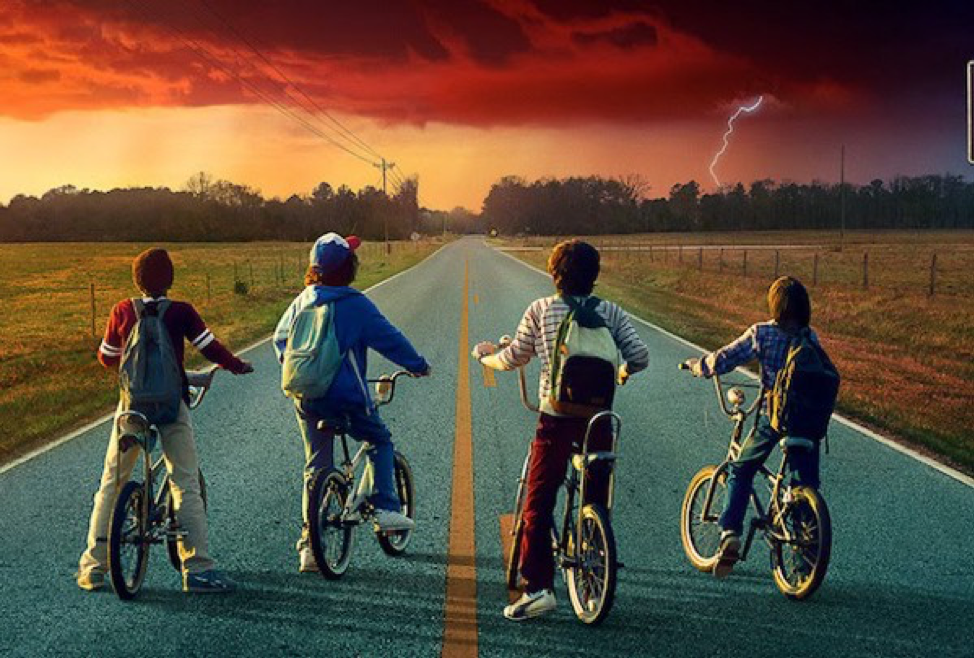 Kid on bikes looking out at a stormy horizon.