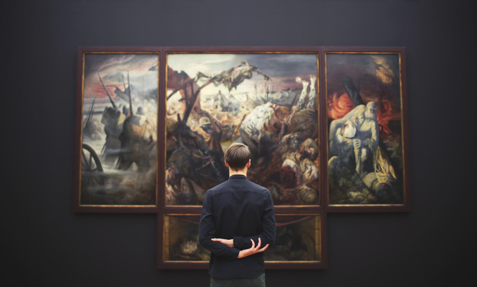 a man in suit observing art