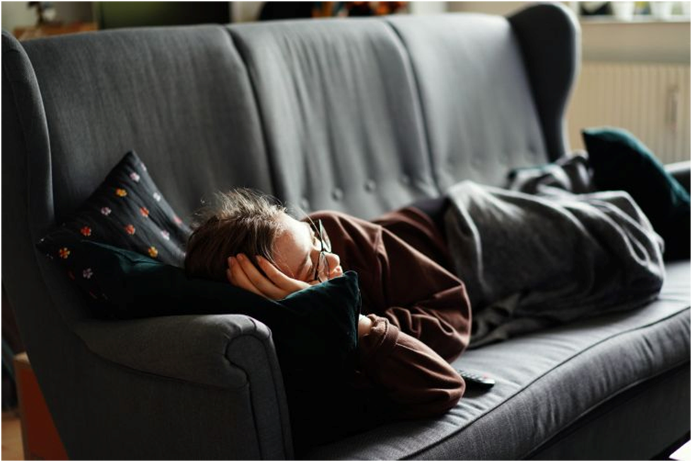 A lazy girl sleeping on a black sofa