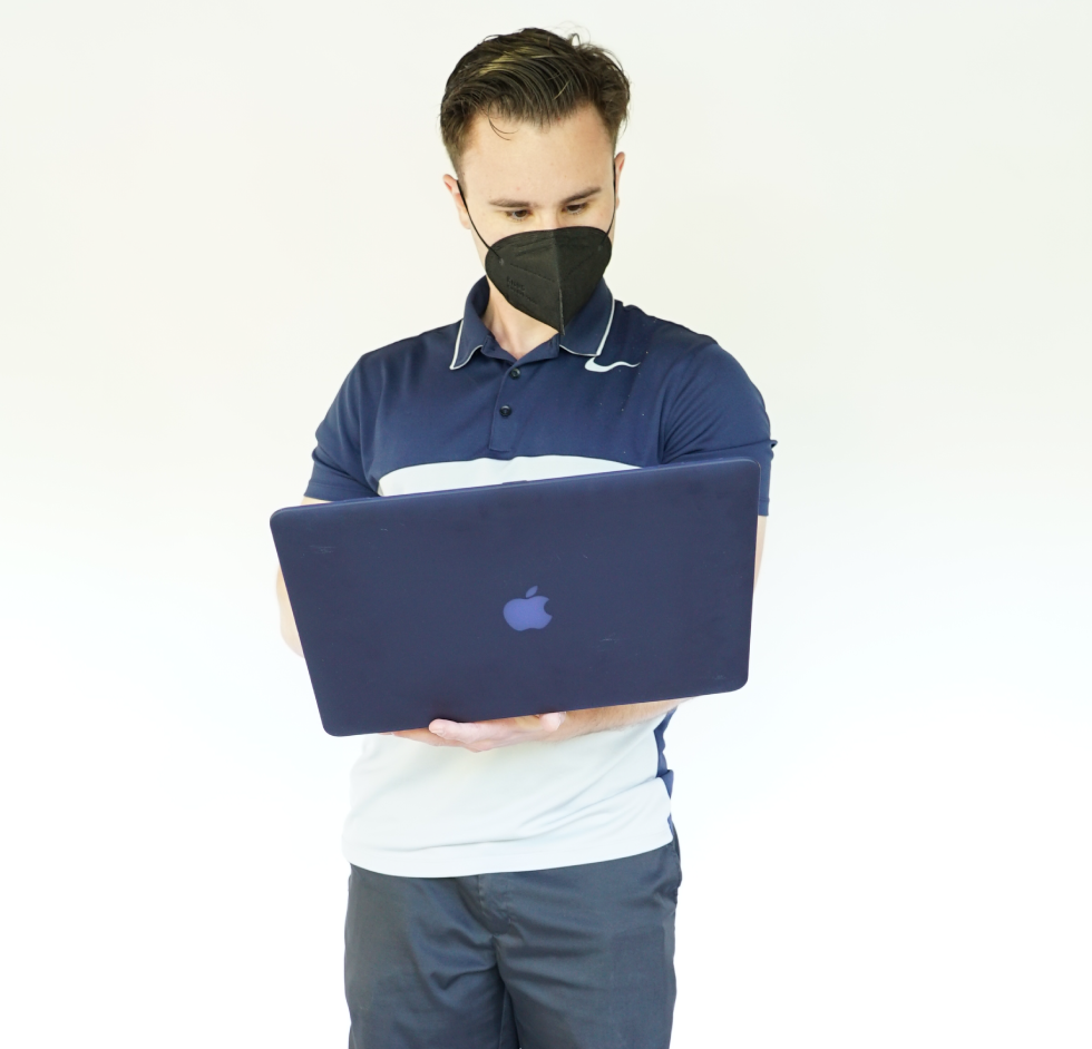 A man looks at a computer while standing up.