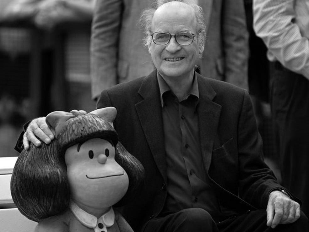 Foto do Quino, criador da Mafalda, sentado ao lado da estátua dela, em San Telmo, Argentina.