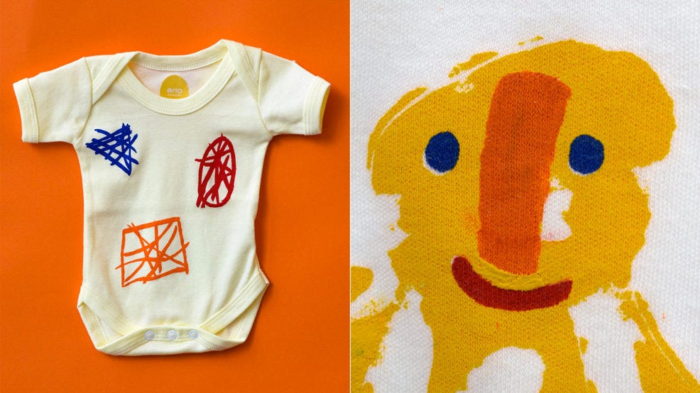 A hand-made gender neutral babygrow featuring illustrated patterns