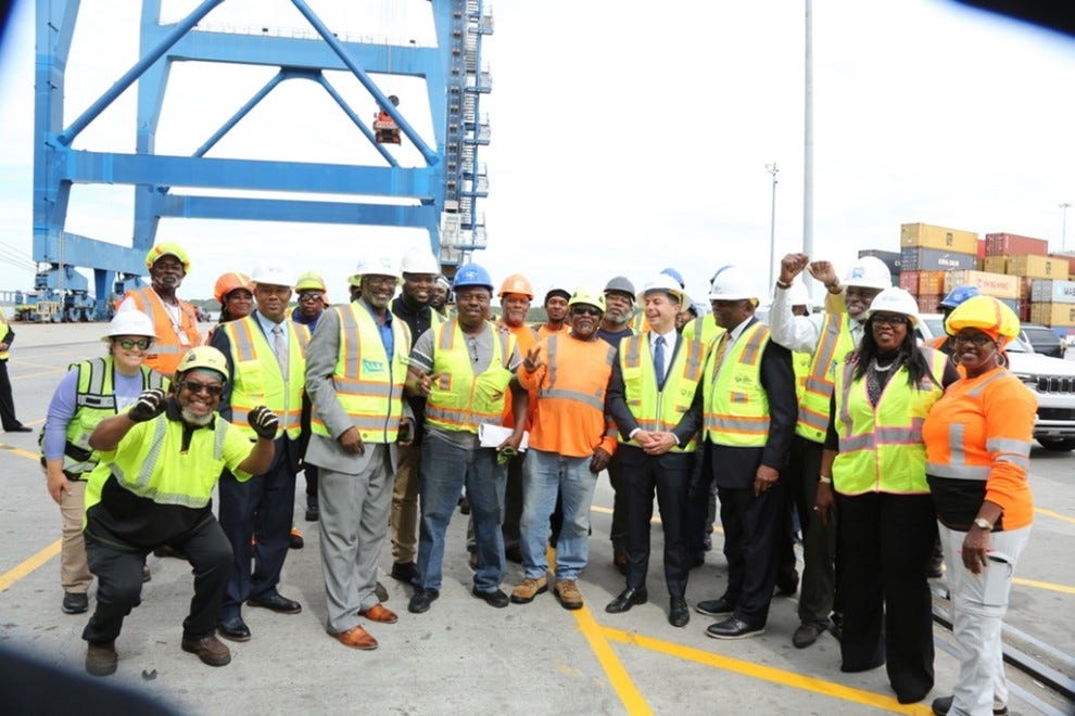 Secretary Buttigieg poses with port workers for a photo.