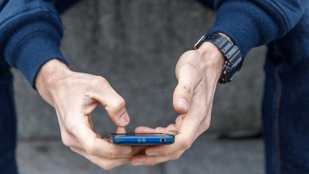 A man`s hands getting a mobile phone.