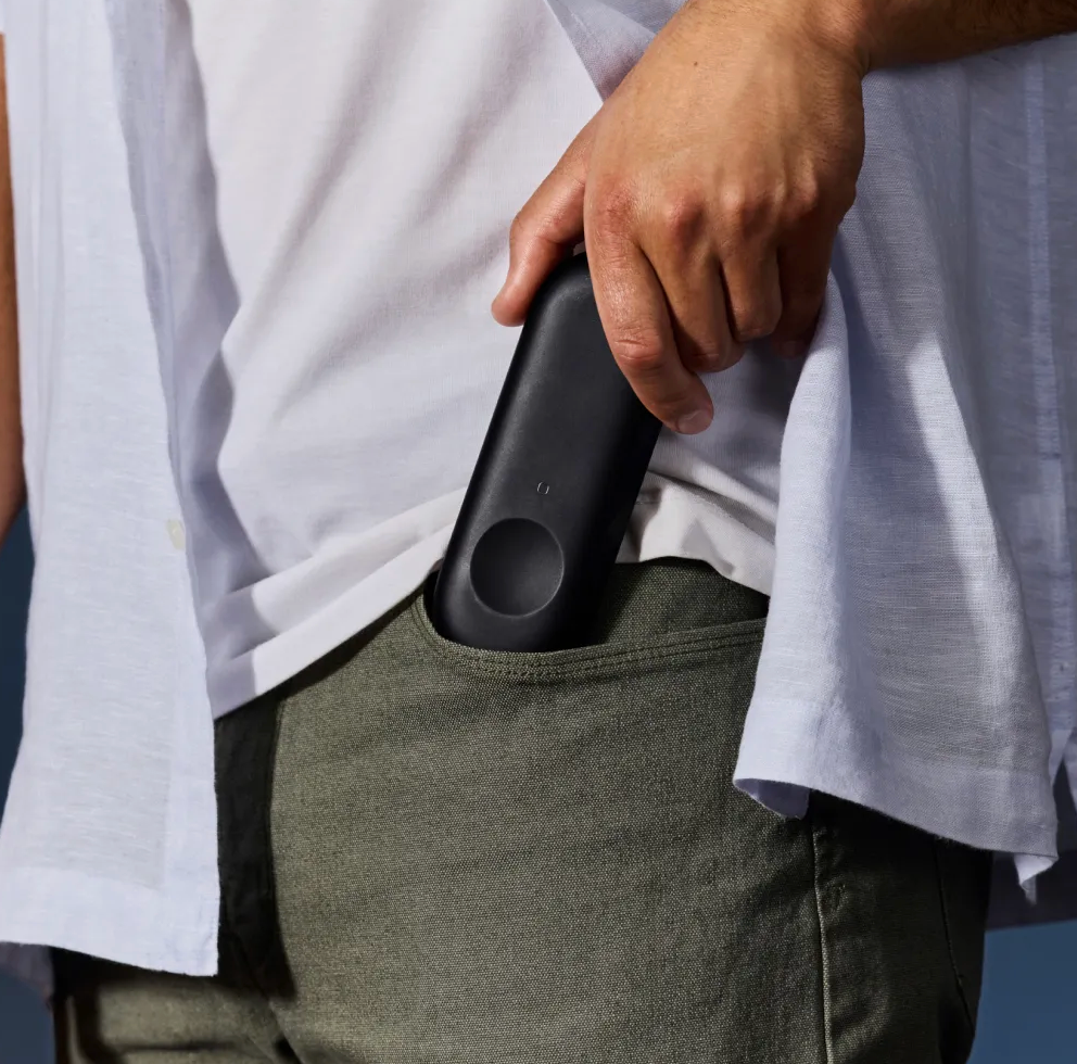 Man placing rectangular oval shaped puck in his pocket