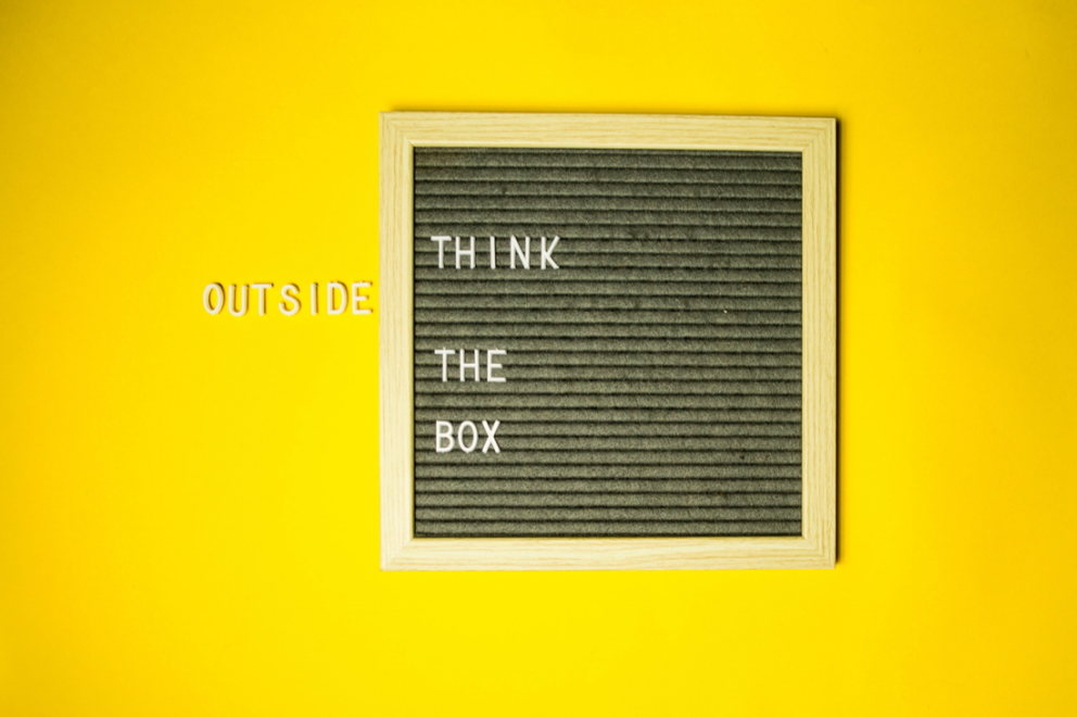 Yellow background with black box that states Think Outside The Box.