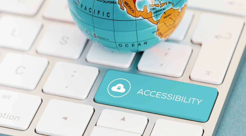 a small metal toy globe sits on a computer keyboard. one of the keys is labeled “accessibility.”