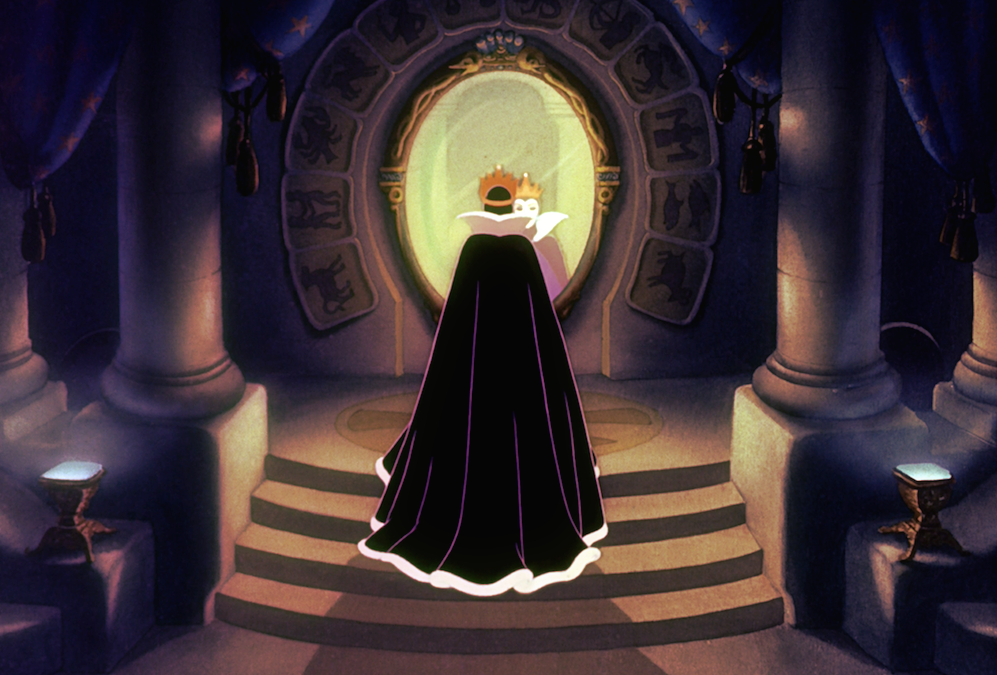 The evil queen standing in front of her large, magic mirror.