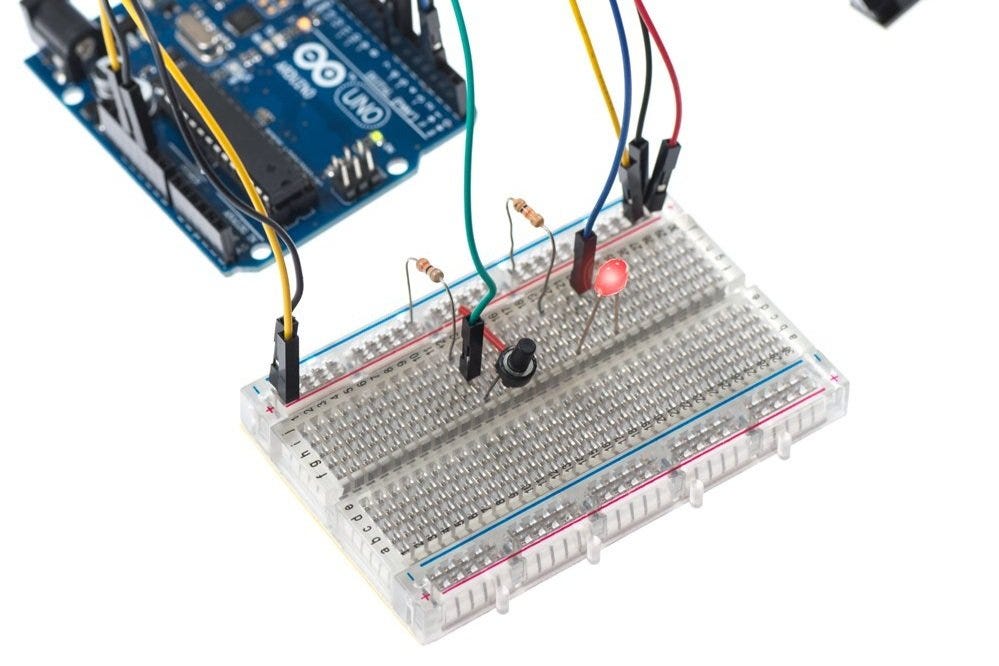 This is a breadboard prototype of a wireless button uses a printed circuit board, a button, and an indicator light. Even simple components like these are in high demand following the pandemic. Chinese manufacturing delays have made the world wait.