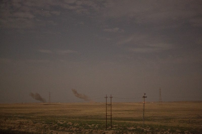 29/09/2015. Kirkuk, Iraq. Dust and smoke rises from the site of coalition airstrikes carries out on Islamic State positions in preparation for a large assault to capture several militant held villages to the west of Kirkuk, Iraq. Supported by coalition airstrikes around 3500 peshmerga of the Patriotic Union of Kurdistan (PUK) and the Kurdistan Democratic Party (KDP) engaged in a large offensive to push Islamic State militants out of villages to the west of Kirkuk. During previous offensives ISIS fighters withdrew after sustained coalition air support, but this time in many places militants stayed and fought. The day would see the coalition conduct around 50 airstrikes helping the joint peshmerga force to advance to within a few kilometres of the ISIS stronghold of Hawija and re-take around 17 villages. Around 20 peshmerga lost their lives to improvised explosive devices left by the Islamic State, reports suggest that between 40 and 150 militants were killed.