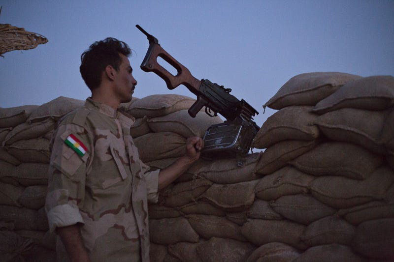 01/09/2015. Bashiqa, Iraq. An Iranian Kurdish peshmerga fighter, belonging to the PAK group, watches from the emplacement where they man a defensive line alongside Kurdish peshmerga on Bashiqa Mountain near Mosul, Iraq. Bashiqa Mountain, towering over the town of the same name, is now a heavily fortified front line. Kurdish peshmerga, having withdrawn to the mountain after the August 2014 ISIS offensive, now watch over Islamic State held territory from their sandbagged high-ground positions. Regular exchanges of fire take place between the Kurds and the Islamic militants with the occupied Iraqi city of Mosul forming the backdrop. The town of Bashiqa, a formerly mixed town that had a population of Yazidi, Kurd, Arab and Shabak, now lies empty apart from insurgents. Along with several other urban sprawls the town forms one of the gateways to Iraq's second largest city that will need to be dealt with should the Kurds be called to advance on Mosul.