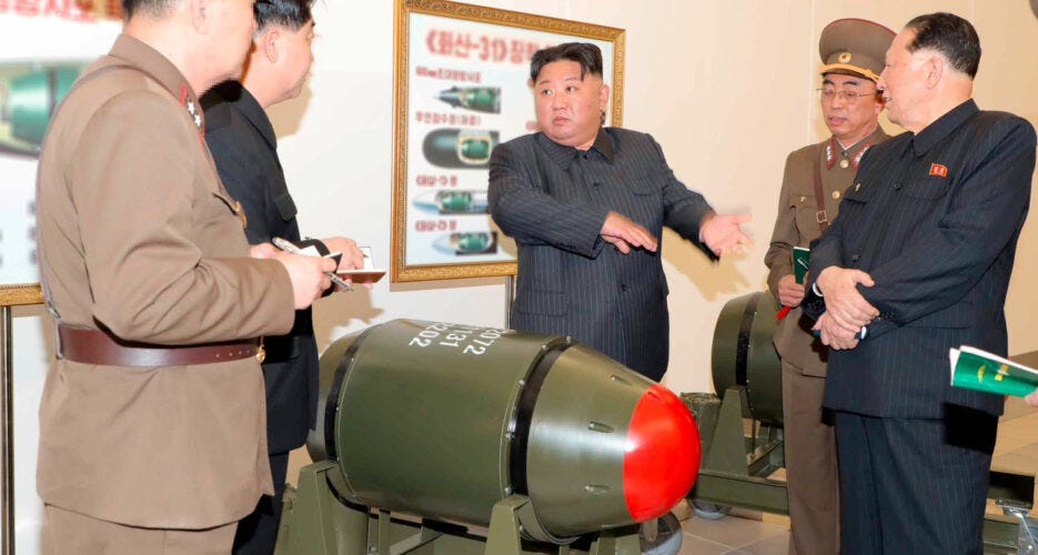 Kim Jong-un inspects a nuclear warhead with North Korean military officials.