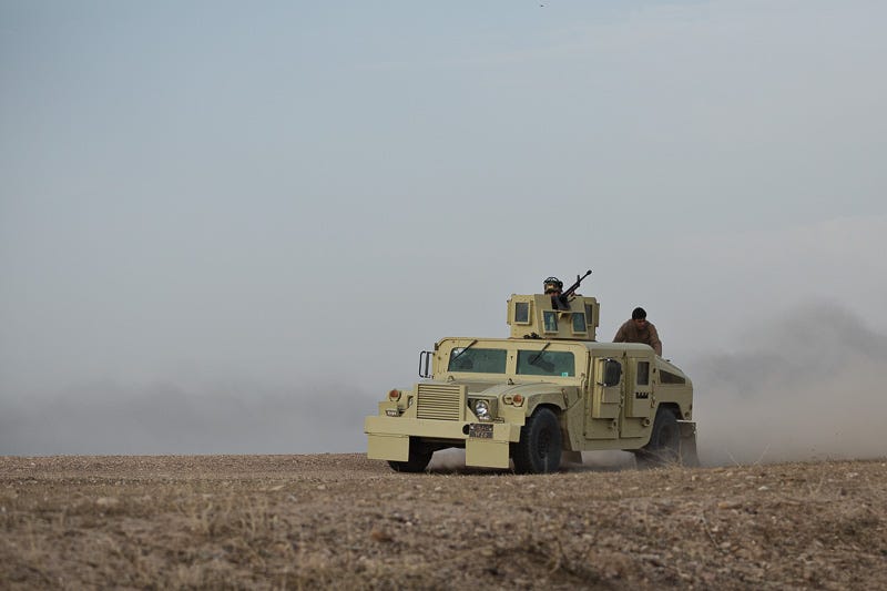 30/09/2015. Kirkuk, Iraq. An KDP peshmerga armoured Humvee, armed with a DShK 12.7mm heavy machine gun, changes position to give support to peshmerga engaging Islamic State militants holding out in the village of Mansuriya, west of Kirkuk, Iraq. Supported by coalition airstrikes around 3500 peshmerga of the Patriotic Union of Kurdistan (PUK) and the Kurdistan Democratic Party (KDP) engaged in a large offensive to push Islamic State militants out of villages to the west of Kirkuk. During previous offensives ISIS fighters withdrew after sustained coalition air support, but this time in many places militants stayed and fought. The day would see the coalition conduct around 50 airstrikes helping the joint peshmerga force to advance to within a few kilometres of the ISIS stronghold of Hawija and re-take around 17 villages. Around 20 peshmerga lost their lives to improvised explosive devices left by the Islamic State, reports suggest that between 40 and 150 militants were killed.