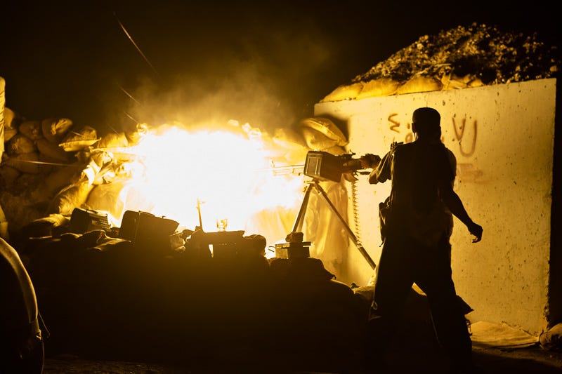 01/09/2015. Bashiqa, Iraq. A Kurdish peshmerga fighter fires a DShK heavy machine gun at ISIS vehicles moving near his unit's defensive position on Bashiqa Mountain, Iraq. Bashiqa Mountain, towering over the town of the same name, is now a heavily fortified front line. Kurdish peshmerga, having withdrawn to the mountain after the August 2014 ISIS offensive, now watch over Islamic State held territory from their sandbagged high-ground positions. Regular exchanges of fire take place between the Kurds and the Islamic militants with the occupied Iraqi city of Mosul forming the backdrop. The town of Bashiqa, a formerly mixed town that had a population of Yazidi, Kurd, Arab and Shabak, now lies empty apart from insurgents. Along with several other urban sprawls the town forms one of the gateways to Iraq's second largest city that will need to be dealt with should the Kurds be called to advance on Mosul.