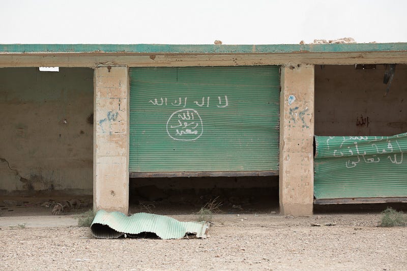 30/09/2015. Kirkuk, Iraq. Islamic State graffiti is seen on the doors of a garage in an area recently liberated by Kurdish peshmerga during a large offensive to push militants out of an area to the west of Kirkuk, Iraq. Supported by coalition airstrikes around 3500 peshmerga of the Patriotic Union of Kurdistan (PUK) and the Kurdistan Democratic Party (KDP) engaged in a large offensive to push Islamic State militants out of villages to the west of Kirkuk. During previous offensives ISIS fighters withdrew after sustained coalition air support, but this time in many places militants stayed and fought. The day would see the coalition conduct around 50 airstrikes helping the joint peshmerga force to advance to within a few kilometres of the ISIS stronghold of Hawija and re-take around 17 villages. Around 20 peshmerga lost their lives to improvised explosive devices left by the Islamic State, reports suggest that between 40 and 150 militants were killed.