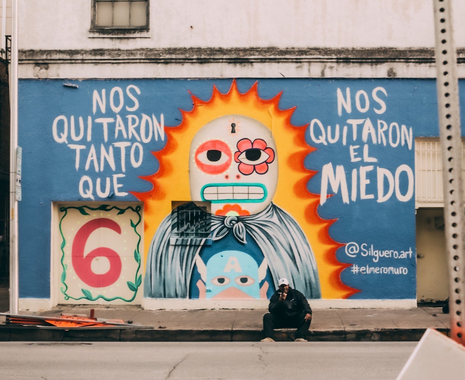 A photo of a mural on the side of a building. The mural shows a cartoon figure with what looks like fire around it and the words “nos quitaron tanto que nos quitaron el miedo” written on either side.