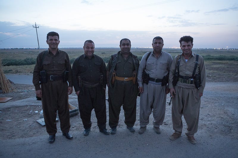 30/09/2015. Kirkuk, Iraq. Volunteer peshmerga: Zana (L), Aram (2L), Hardi (C), Sarwar (2R) and Hadji Fazer (R) stand for a group picture before taking part in a large offensive against ISIS held villages west of Kirkuk, Iraq. Supported by coalition airstrikes around 3500 peshmerga of the Patriotic Union of Kurdistan (PUK) and the Kurdistan Democratic Party (KDP) engaged in a large offensive to push Islamic State militants out of villages to the west of Kirkuk. During previous offensives ISIS fighters withdrew after sustained coalition air support, but this time in many places militants stayed and fought. The day would see the coalition conduct around 50 airstrikes helping the joint peshmerga force to advance to within a few kilometres of the ISIS stronghold of Hawija and re-take around 17 villages. Around 20 peshmerga lost their lives to improvised explosive devices left by the Islamic State, reports suggest that between 40 and 150 militants were killed.