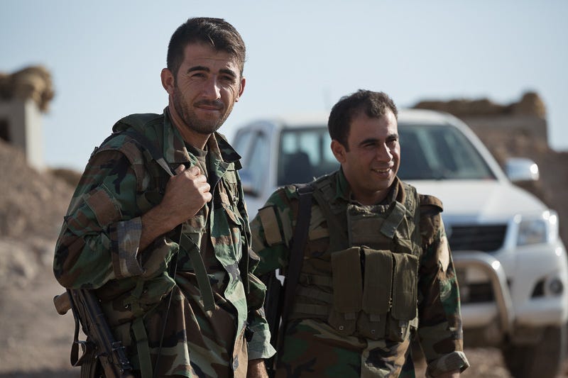 01/09/2015. Bashiqa, Iraq. Kurdish peshmerga chat between guard shifts at a defensive positon on the top of Bashiqa Mountain near Mosul, Iraq. Bashiqa Mountain, towering over the town of the same name, is now a heavily fortified front line. Kurdish peshmerga, having withdrawn to the mountain after the August 2014 ISIS offensive, now watch over Islamic State held territory from their sandbagged high-ground positions. Regular exchanges of fire take place between the Kurds and the Islamic militants with the occupied Iraqi city of Mosul forming the backdrop. The town of Bashiqa, a formerly mixed town that had a population of Yazidi, Kurd, Arab and Shabak, now lies empty apart from insurgents. Along with several other urban sprawls the town forms one of the gateways to Iraq's second largest city that will need to be dealt with should the Kurds be called to advance on Mosul.