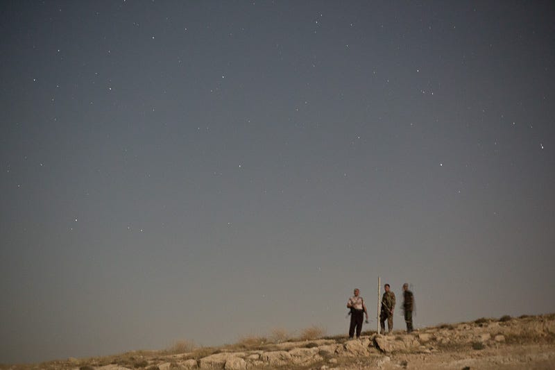 01/09/2015. Bashiqa, Iraq. Kurdish peshmerga fighters check on a light, used to illuminate the ground in front of their defensive position, on Bashiqa Mountain, Iraq. Bashiqa Mountain, towering over the town of the same name, is now a heavily fortified front line. Kurdish peshmerga, having withdrawn to the mountain after the August 2014 ISIS offensive, now watch over Islamic State held territory from their sandbagged high-ground positions. Regular exchanges of fire take place between the Kurds and the Islamic militants with the occupied Iraqi city of Mosul forming the backdrop. The town of Bashiqa, a formerly mixed town that had a population of Yazidi, Kurd, Arab and Shabak, now lies empty apart from insurgents. Along with several other urban sprawls the town forms one of the gateways to Iraq's second largest city that will need to be dealt with should the Kurds be called to advance on Mosul.