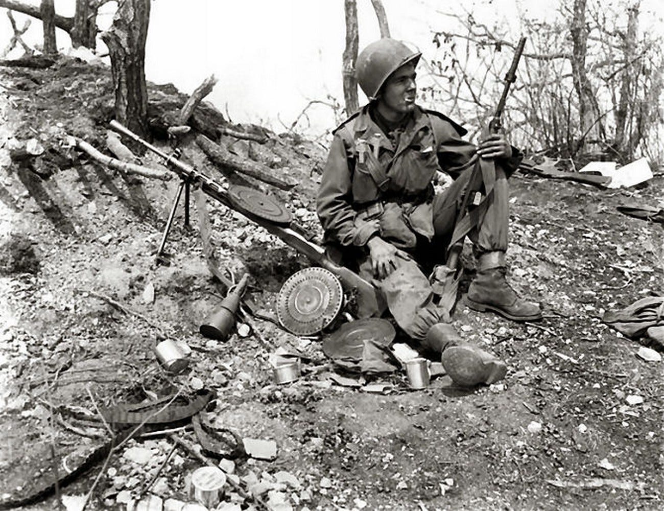 Pfc. Julias Van Den Stock of Company A, 32nd Regimental Combat Team, 7th Infantry Division, rests on a Chinese Communist bunker with a Soviet DP light machine gun, along the slope of Hill 902 north of Ip-Tong, 1951. U.S. Marine Corps photo. 