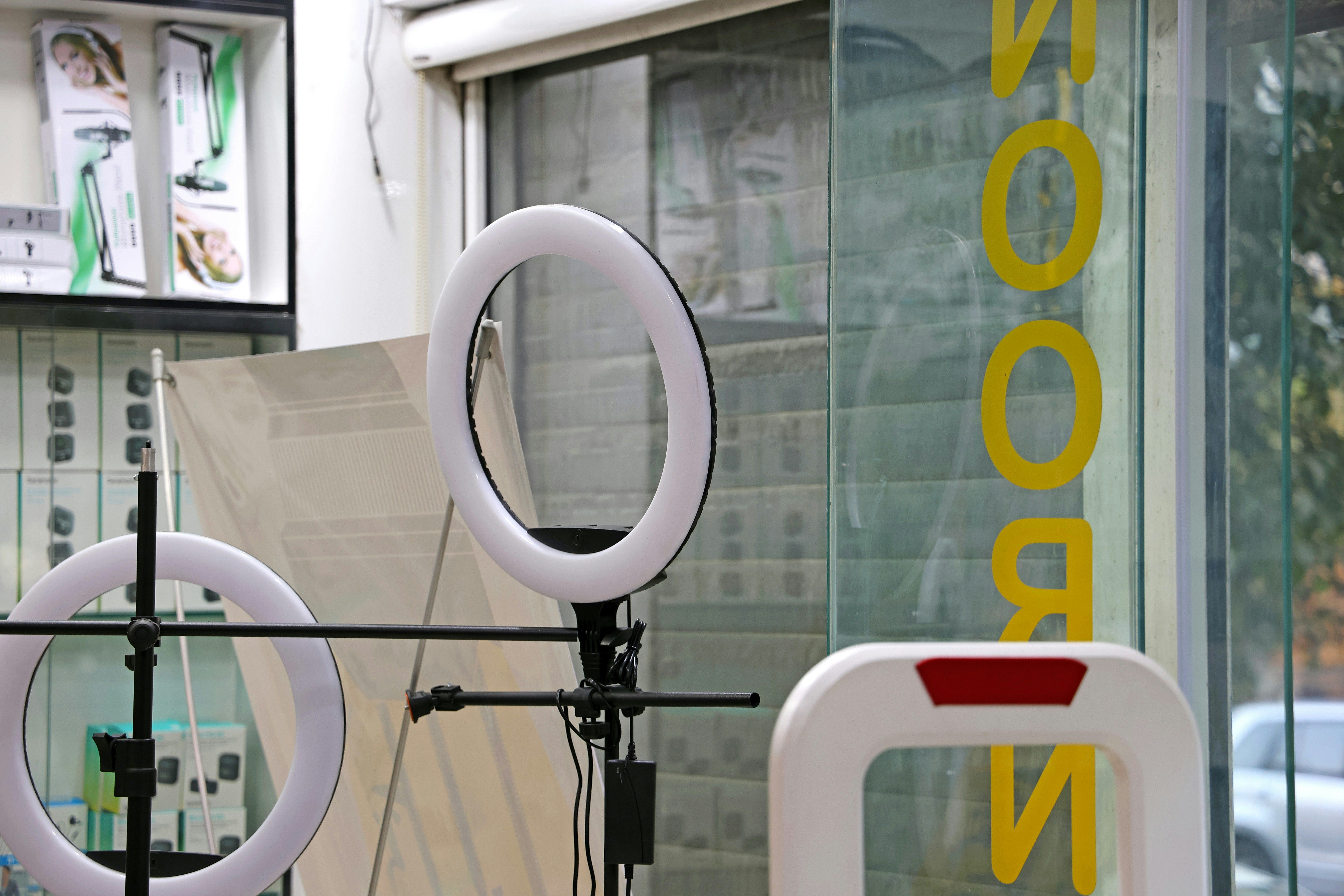 Two ring lights on stands inside a store entrance.