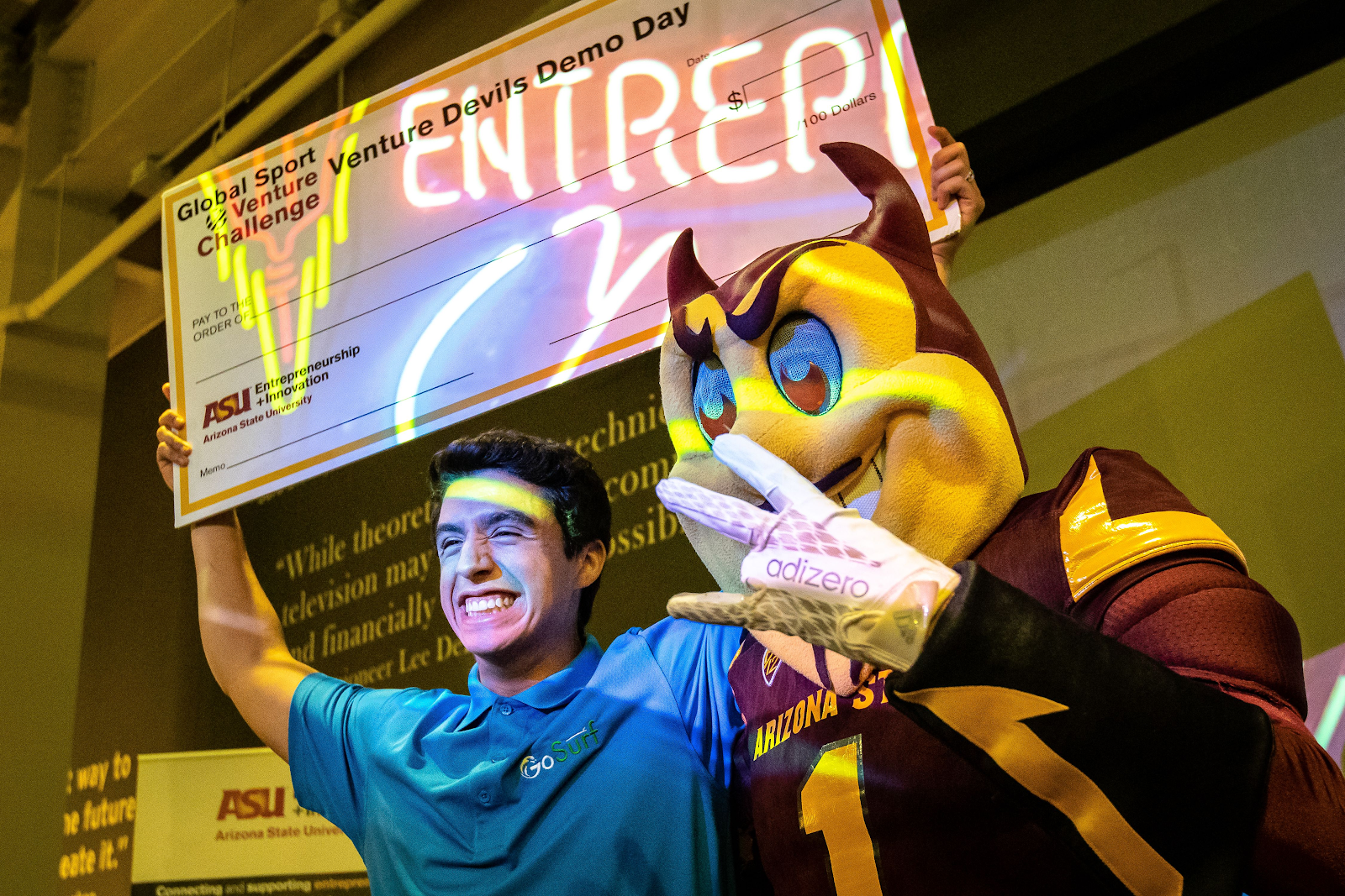 Aleksei Stojanovic, founder of GoSurf, poses at Venture Devils Demo Day with ASU mascot and giant check