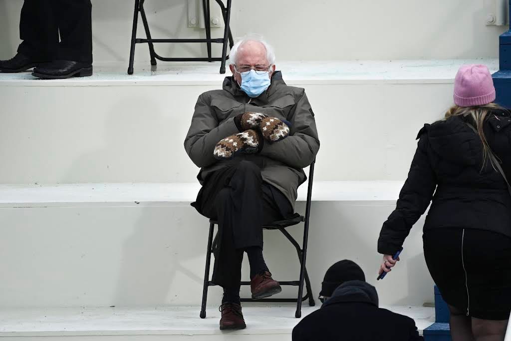 Photo of Bernie Sanders at inauguration in winter jacket and striped mittens