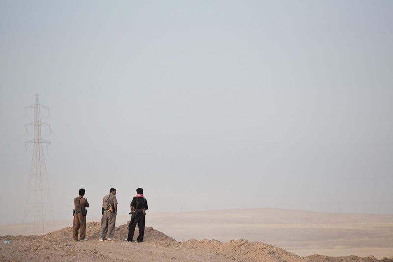 30/09/2015. Kirkuk, Iraq. The Kurdish peshmerga fighters look in to no-man's land from a Kurdish front line position as they wait for the start of a large offensive against Islamic State held villages to the west of Kirkuk, Iraq. Supported by coalition airstrikes around 3500 peshmerga of the Patriotic Union of Kurdistan (PUK) and the Kurdistan Democratic Party (KDP) engaged in a large offensive to push Islamic State militants out of villages to the west of Kirkuk. During previous offensives ISIS fighters withdrew after sustained coalition air support, but this time in many places militants stayed and fought. The day would see the coalition conduct around 50 airstrikes helping the joint peshmerga force to advance to within a few kilometres of the ISIS stronghold of Hawija and re-take around 17 villages. Around 20 peshmerga lost their lives to improvised explosive devices left by the Islamic State, reports suggest that between 40 and 150 militants were killed.